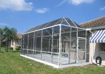 Gable-style screen enclosure with a blue-and-white striped awning beside a palm tree.